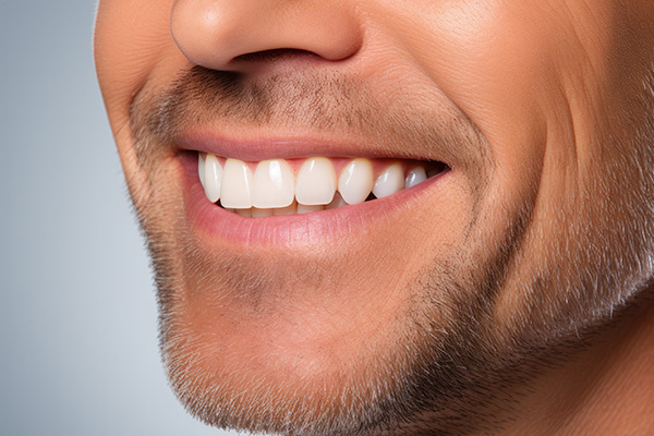 A man with a mustache and goatee smiling at the camera.