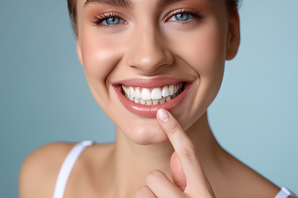 A woman with a radiant smile looking at her teeth.