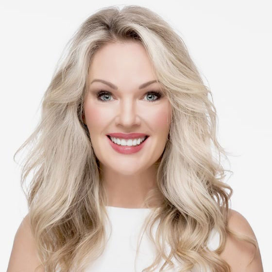 A smiling woman with blond hair posing for a portrait.