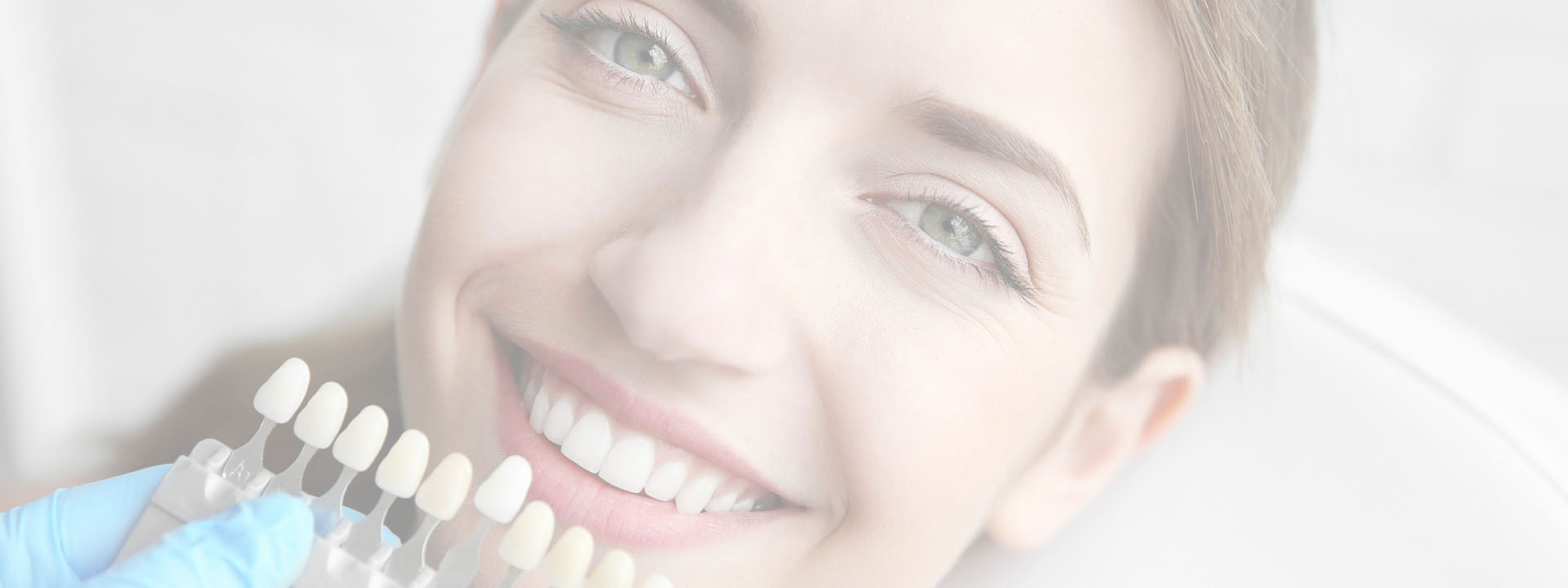 A woman with a radiant smile, holding a tray of dental implants, showcasing her work as a dental professional.