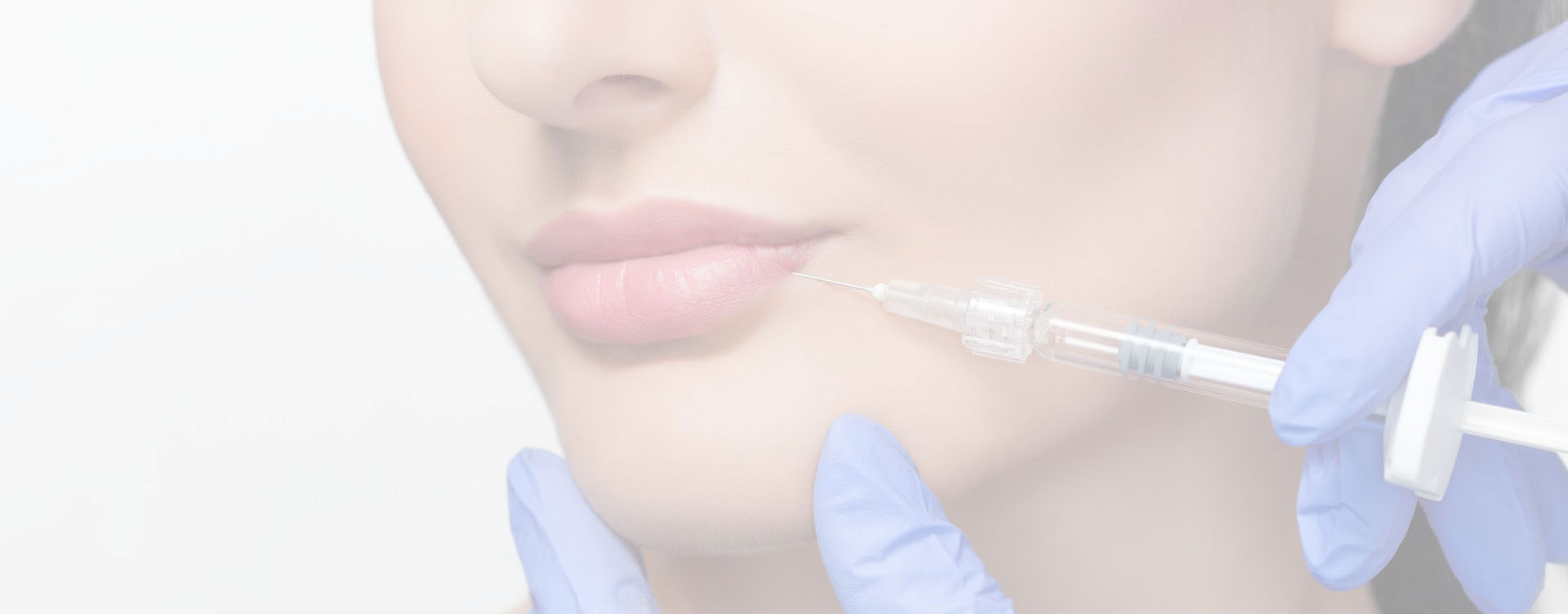 The image shows a woman with a mask over her nose and mouth, looking directly at the camera, with a focus on her face and the medical device she s holding near her cheek.