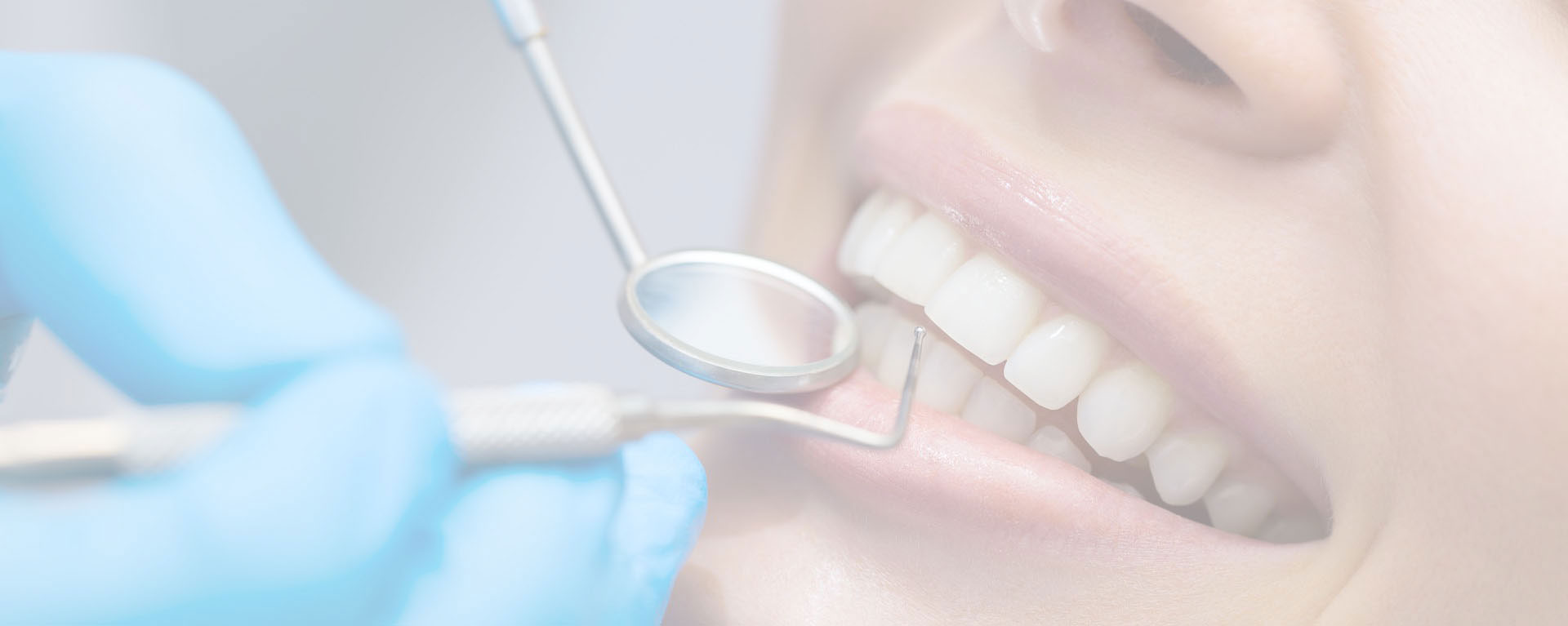 A woman wearing blue gloves is seated at a dental chair with her mouth open, receiving dental care from a professional who appears to be adjusting her teeth with tools.