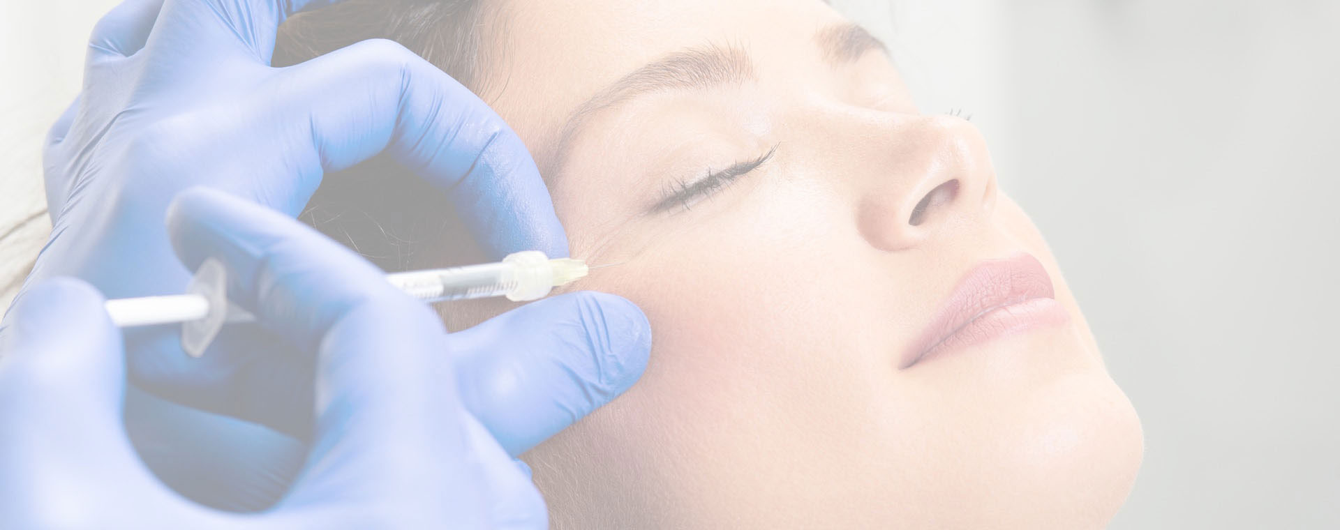 The image shows a person receiving cosmetic treatment at a beauty salon, with a professional using a device on their face while wearing gloves, all under a clean environment.